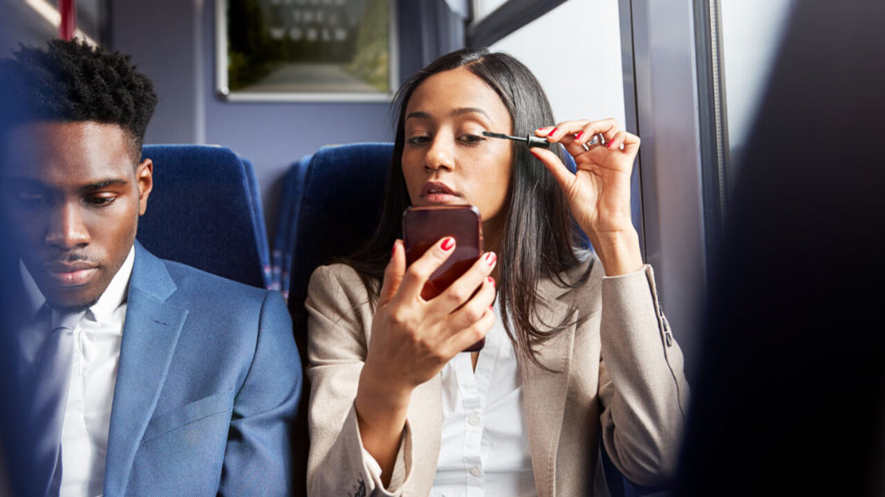 Busy-woman-putting-makeup-on-on-a-train